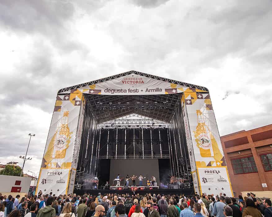 Vista frontal del escenario principal del Degusta Fest Armilla 2026 con numeroso público y un grupo musical actuando en directo en Fermasa Granada