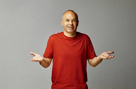 Andrés Iniesta con camiseta roja y gesto de manos abiertas en la campaña La Teoría 116 de MediaMarkt para el Mundial 2026