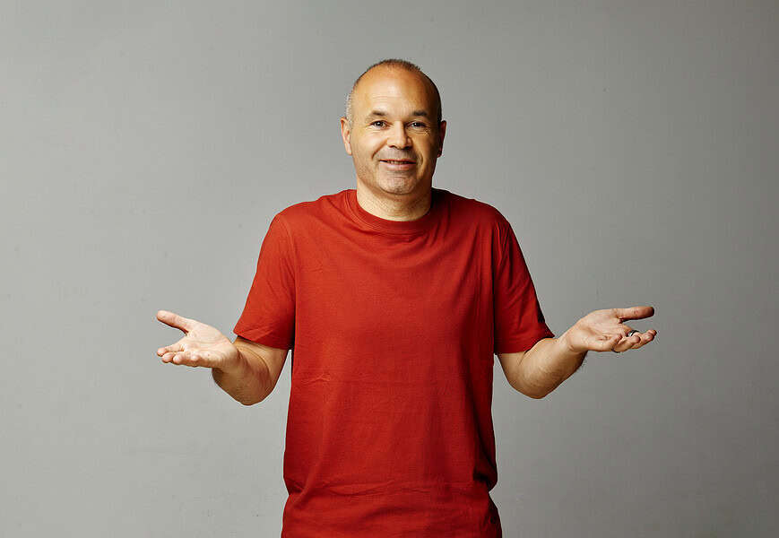 Andrés Iniesta con camiseta roja y gesto de manos abiertas en la campaña La Teoría 116 de MediaMarkt para el Mundial 2026