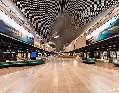 Interior de la Terminal 3 del aeropuerto de Frankfurt con grandes pantallas LED de LG Electronics instaladas en el techo del área Market Place mostrando imágenes de paisajes naturales